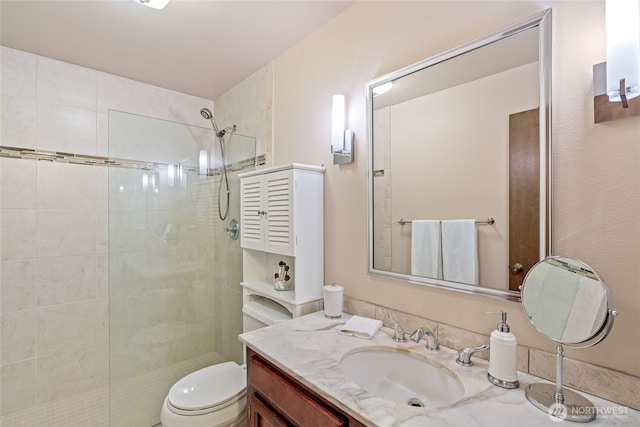 bathroom featuring vanity, a walk in shower, and toilet