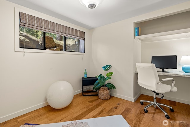 home office with baseboards and wood finished floors