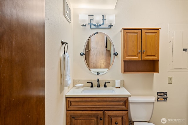 bathroom featuring vanity, electric panel, toilet, and visible vents