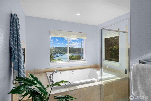 full bathroom with a water view, a stall shower, and a bath