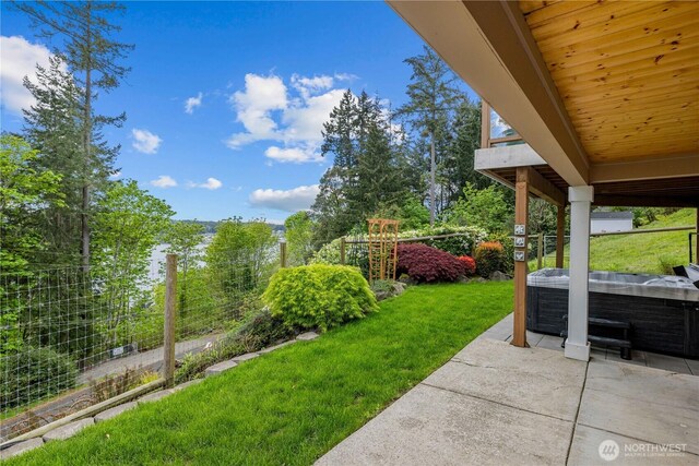 view of yard featuring a hot tub, fence, and a patio area