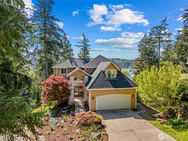 craftsman house featuring a garage, a shingled roof, and concrete driveway