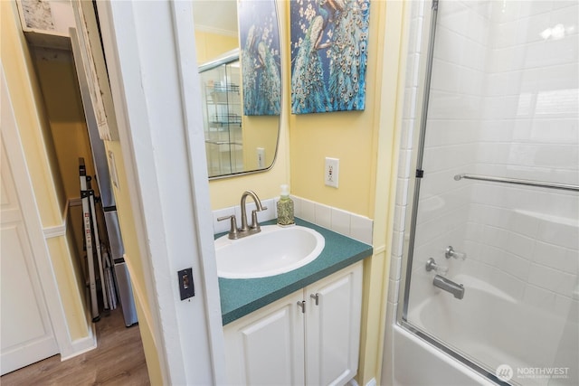 full bath featuring vanity, enclosed tub / shower combo, and wood finished floors