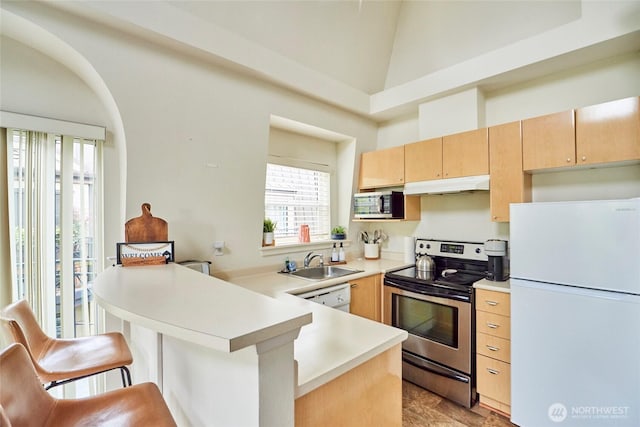425 Vine St Unit 709, Seattle, WA 98121 - kitchen featuring a sink, light countertops, stainless steel appliances, a peninsula, and under cabinet range hood