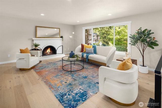living room with baseboards, a brick fireplace, recessed lighting, and wood finished floors