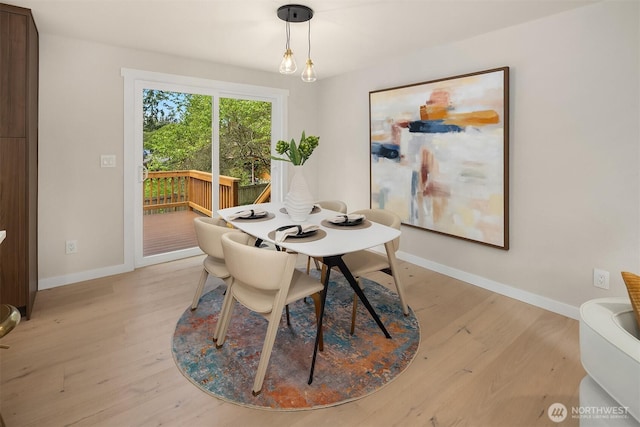 dining area featuring light wood finished floors and baseboards