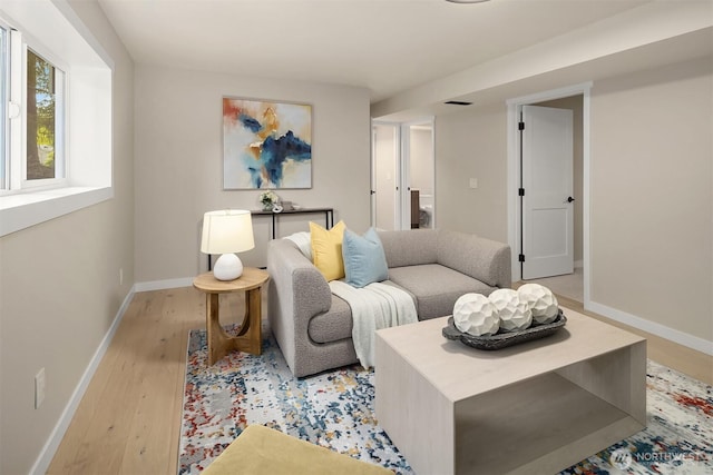 living area featuring light wood-type flooring and baseboards