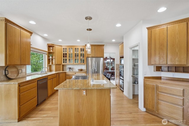 17600 NE 188th Ct, Brush Prairie, WA 98606 - kitchen featuring decorative backsplash, appliances with stainless steel finishes, a center island with sink, a sink, and light stone counters