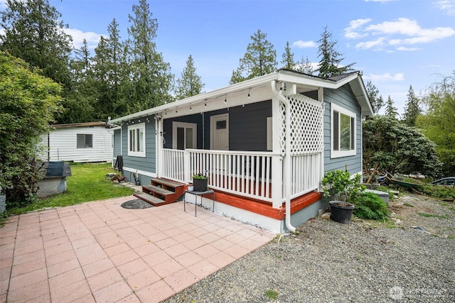 rear view of house with covered porch and a patio area