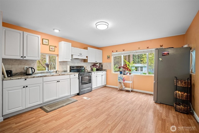 kitchen with under cabinet range hood, stainless steel appliances, a wealth of natural light, and light wood-type flooring