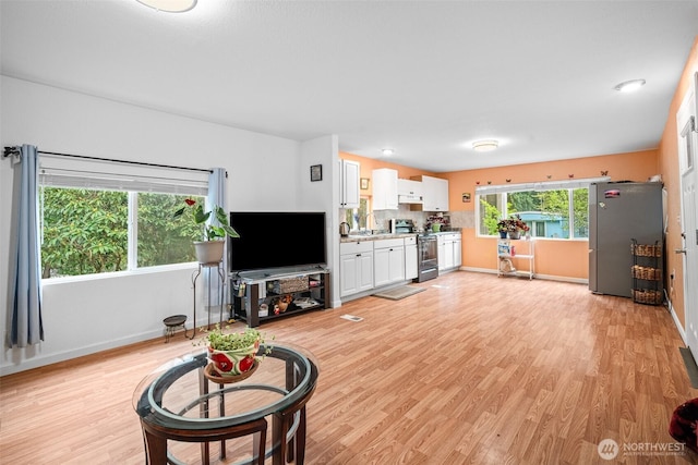 living area with baseboards and light wood-style flooring