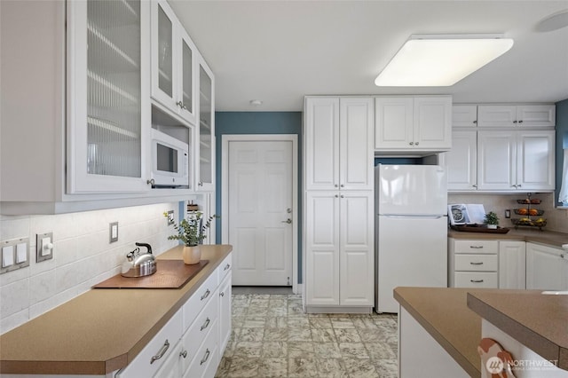 5726 Nakat Way, Blaine, WA 98230 - kitchen featuring glass insert cabinets, white cabinets, white appliances, and tasteful backsplash