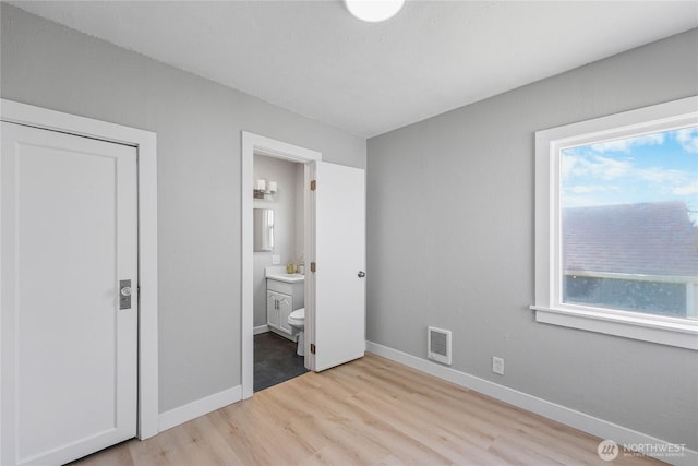10704 5th Ave S, Tacoma, WA 98444 - unfurnished bedroom with light wood-type flooring, baseboards, ensuite bath, and visible vents