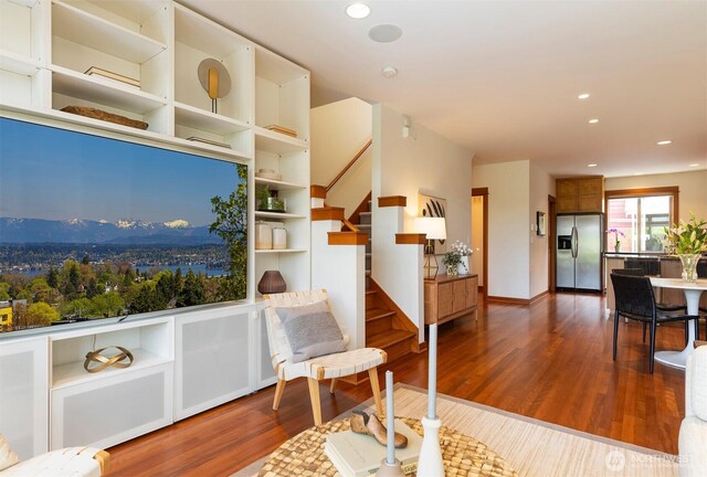 sitting room with recessed lighting, stairs, and dark wood-style floors