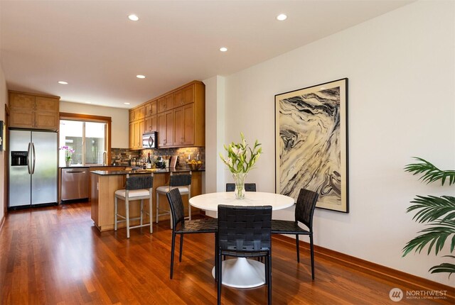 dining space with recessed lighting, baseboards, and dark wood-style floors