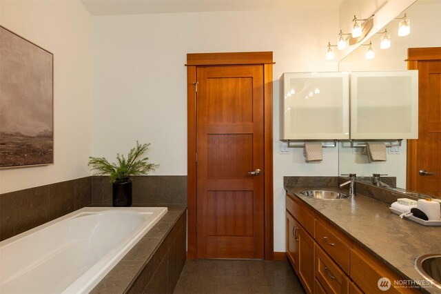 full bath featuring double vanity, a sink, and a bath