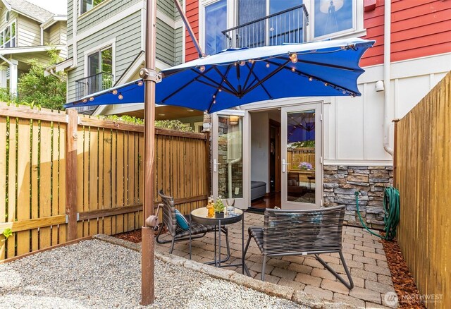 view of patio / terrace featuring fence and a balcony