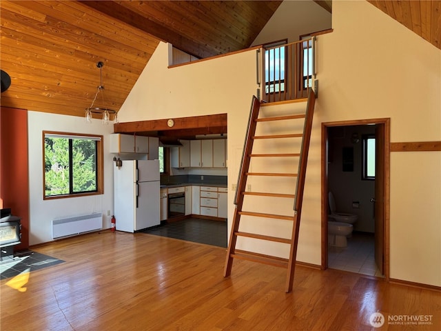 1052 Vusario Ln, Orcas Island, WA 98245 - unfurnished living room featuring wood ceiling, high vaulted ceiling, radiator, stairway, and a wood stove