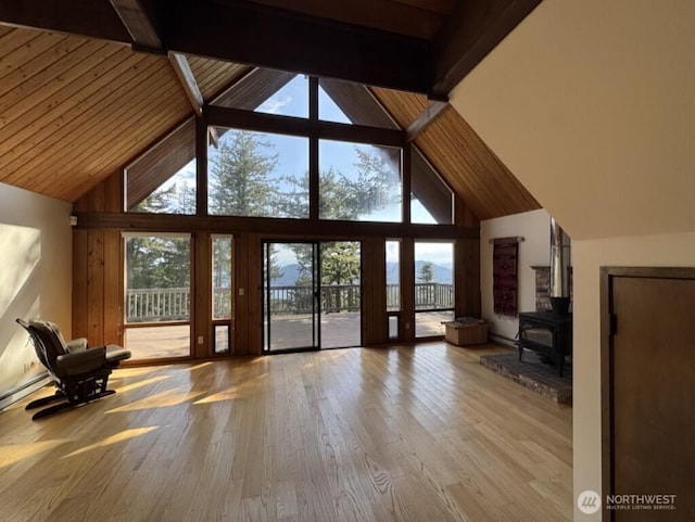 1052 Vusario Ln, Orcas Island, WA 98245 - unfurnished living room featuring a wood stove, a wealth of natural light, and high vaulted ceiling