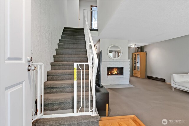 stairway featuring carpet and a brick fireplace