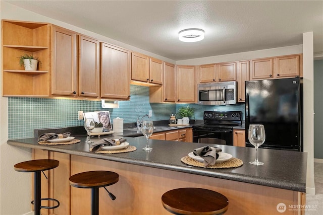 700 Front St S Unit A304, Issaquah, WA 98027 - kitchen with decorative backsplash, a peninsula, black appliances, and dark countertops