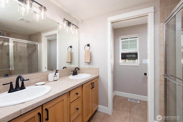 bathroom featuring tile patterned floors, visible vents, a sink, and a stall shower
