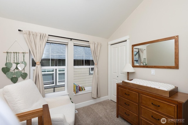 carpeted bedroom with a closet, baseboards, and vaulted ceiling