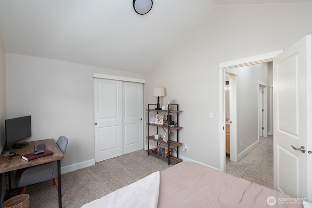 bedroom with a closet, baseboards, lofted ceiling, and light colored carpet