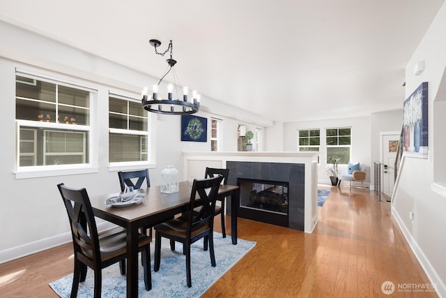 2608 SW Myrtle St, Seattle, WA 98106 - dining area featuring a chandelier, wood finished floors, a tile fireplace, and baseboards