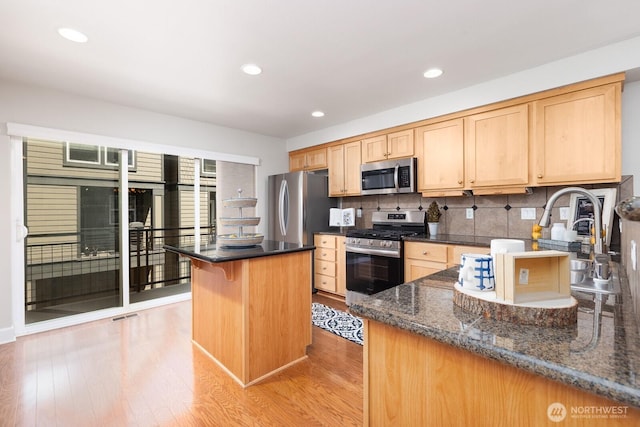 2608 SW Myrtle St, Seattle, WA 98106 - kitchen with appliances with stainless steel finishes, light brown cabinetry, light wood finished floors, backsplash, and recessed lighting