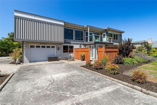 view of front facade featuring fence, an attached garage, and driveway