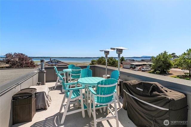 view of patio with a water view and outdoor dining space