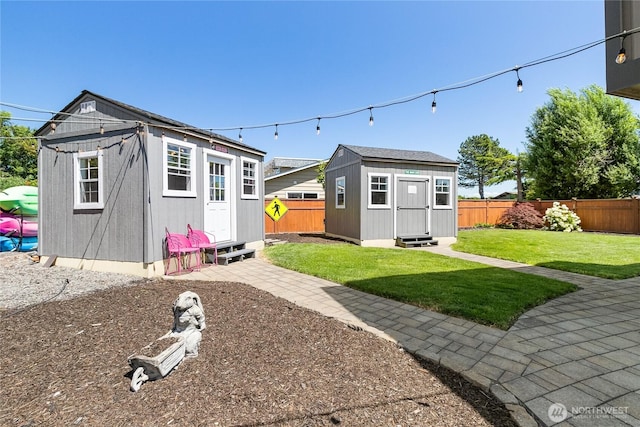 exterior space featuring a fenced backyard, a yard, an outbuilding, and entry steps