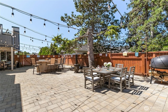view of patio featuring fence, outdoor dry bar, and outdoor dining area