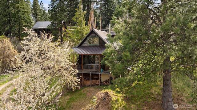 back of property featuring a deck and metal roof