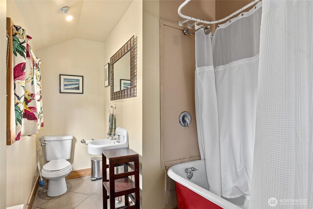 bathroom featuring shower / bath combination with curtain, tile patterned flooring, baseboards, toilet, and lofted ceiling