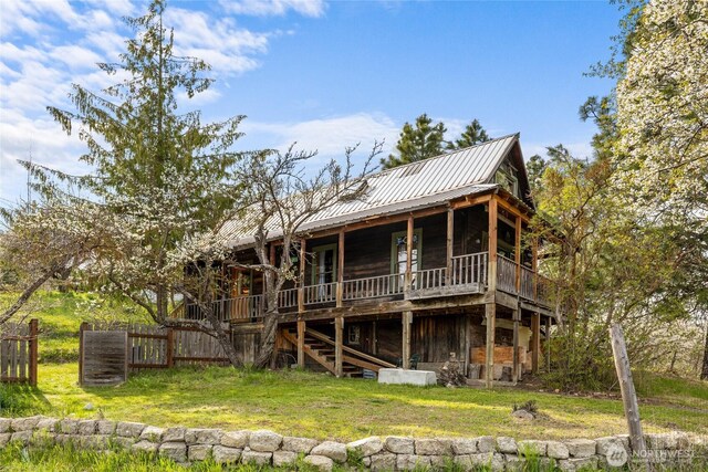 rear view of house featuring a yard, a deck, stairway, and fence