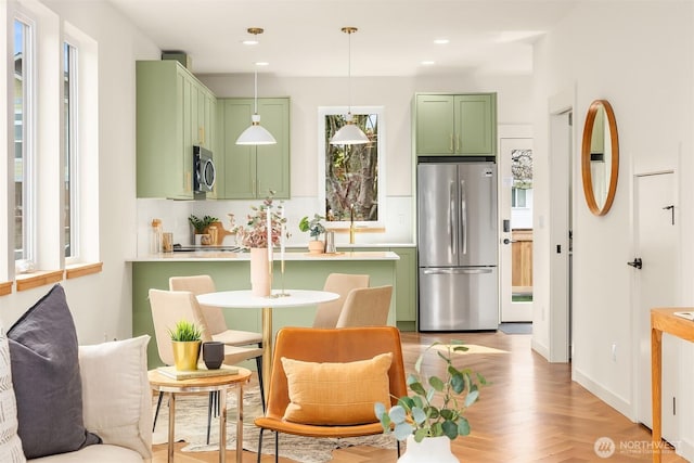 kitchen featuring hanging light fixtures, light countertops, stainless steel appliances, recessed lighting, and green cabinets
