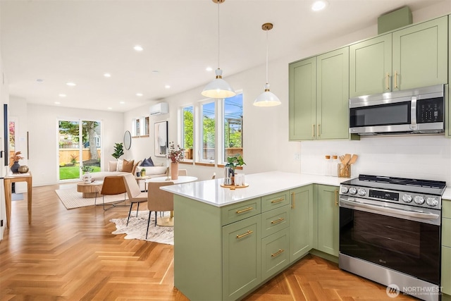 kitchen featuring a wall unit AC, a peninsula, green cabinetry, stainless steel appliances, and recessed lighting