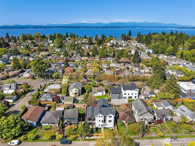 drone / aerial view featuring a water and mountain view and a residential view
