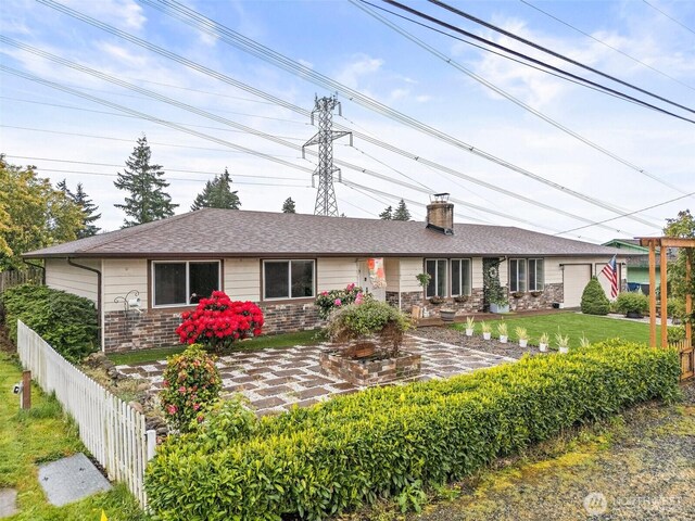 view of front of house featuring fence, a chimney, a front yard, and stone siding