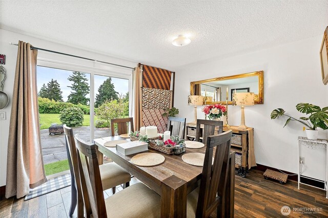 dining area with a textured ceiling and wood finished floors