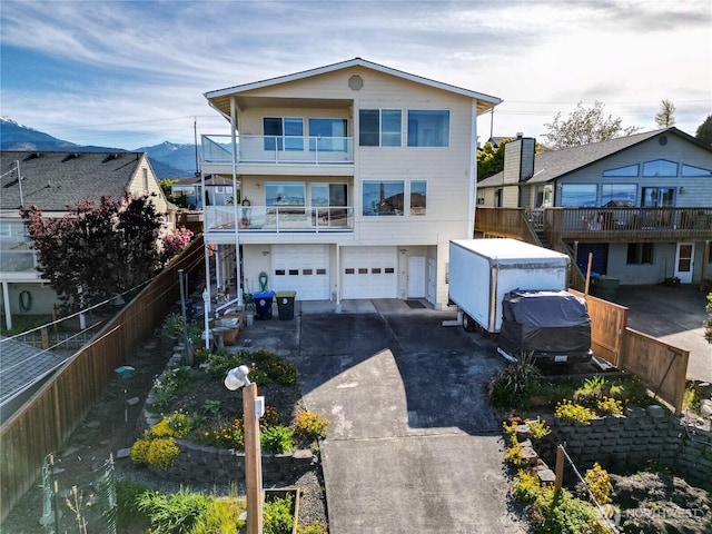 view of front of property with a balcony, driveway, an attached garage, and a mountain view