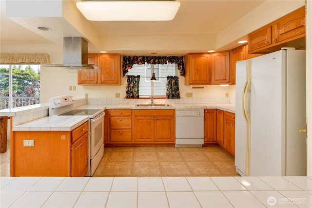 kitchen featuring white appliances, ventilation hood, a sink, tile counters, and a peninsula