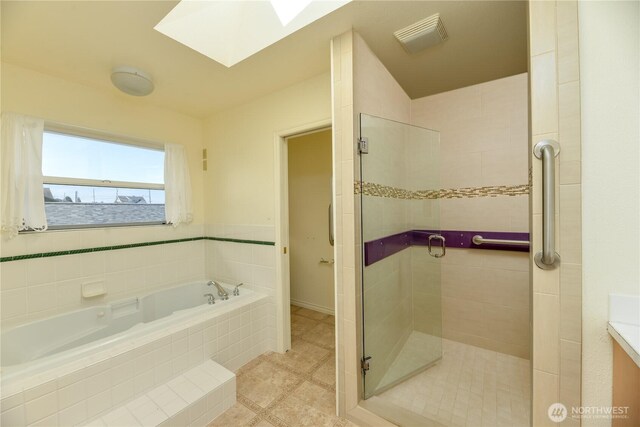 full bath featuring a skylight, a stall shower, a bath, and tile patterned floors