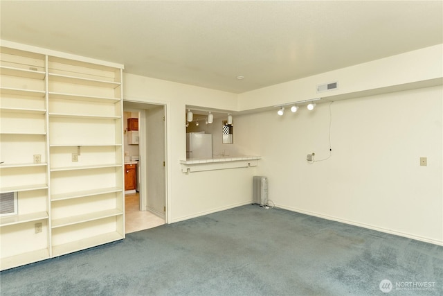 unfurnished living room with radiator heating unit, carpet flooring, and baseboards