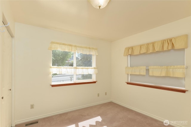 carpeted spare room featuring baseboards