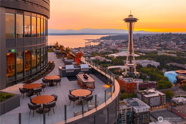view of patio / terrace featuring exterior kitchen, a city view, a water view, and grilling area