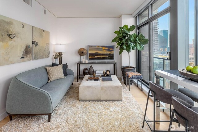 living area featuring visible vents and wood finished floors