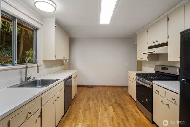 540 SW Fernwood St, Issaquah, WA 98027 - kitchen with stainless steel appliances, under cabinet range hood, a sink, light countertops, and ornamental molding